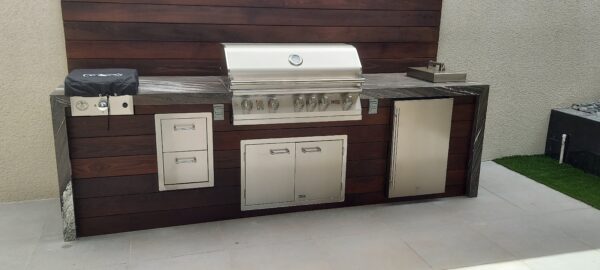 Custom BBQ island with Lion L90000 built-in grill, outdoor refrigerator and dark wood-look paneling in Summerlin South, Las Vegas