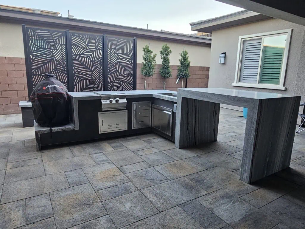 Custom L-shaped outdoor kitchen with built-in grill and bar in Las Vegas