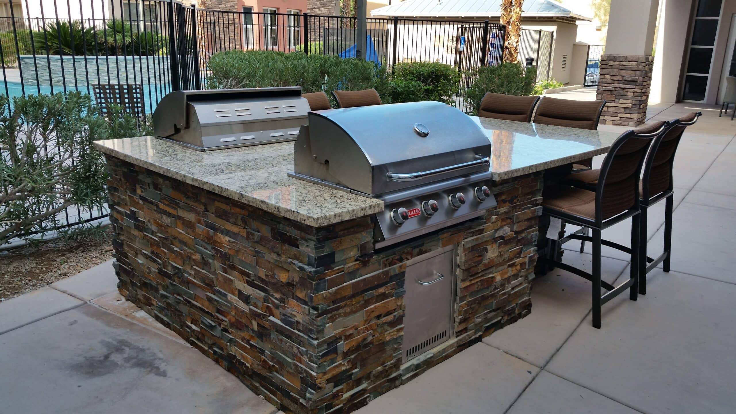 Stacked stone BBQ island with granite bar seating in Las Vegas