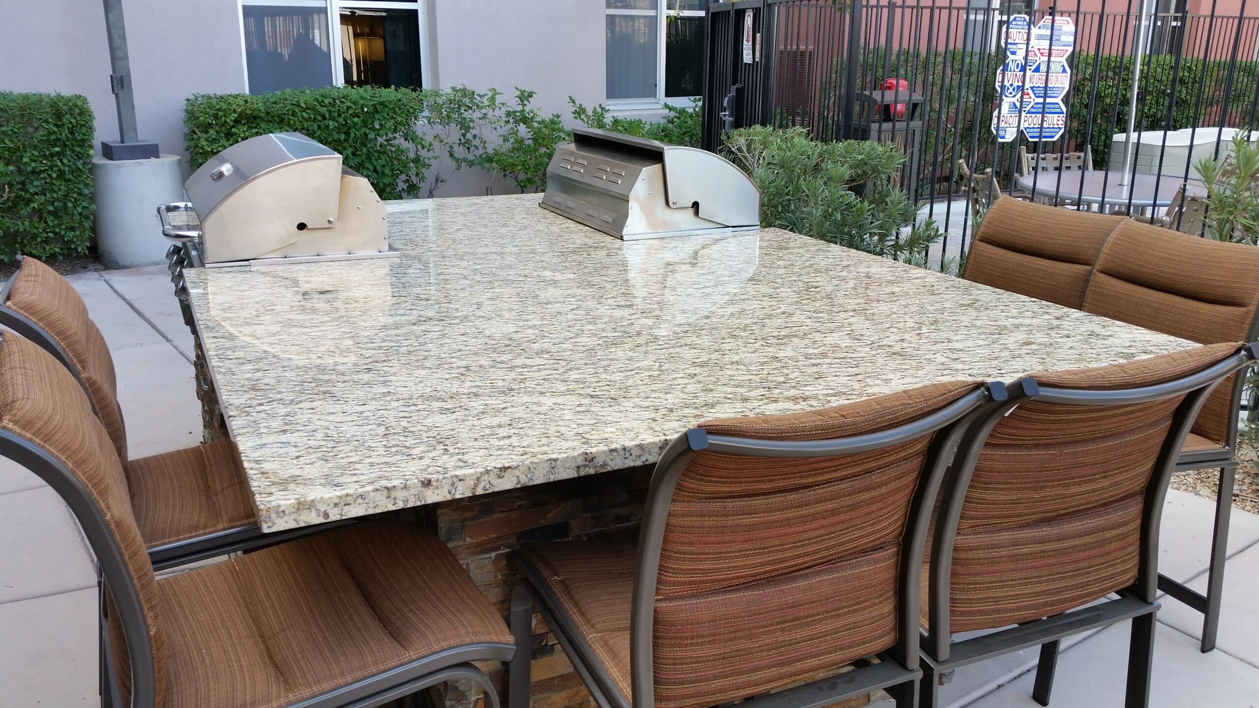 Granite counter overhang with bar chairs on a custom BBQ island in Las Vegas