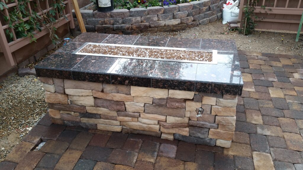 Rectangular stacked-stone fire pit with granite cap in a Las Vegas backyard
