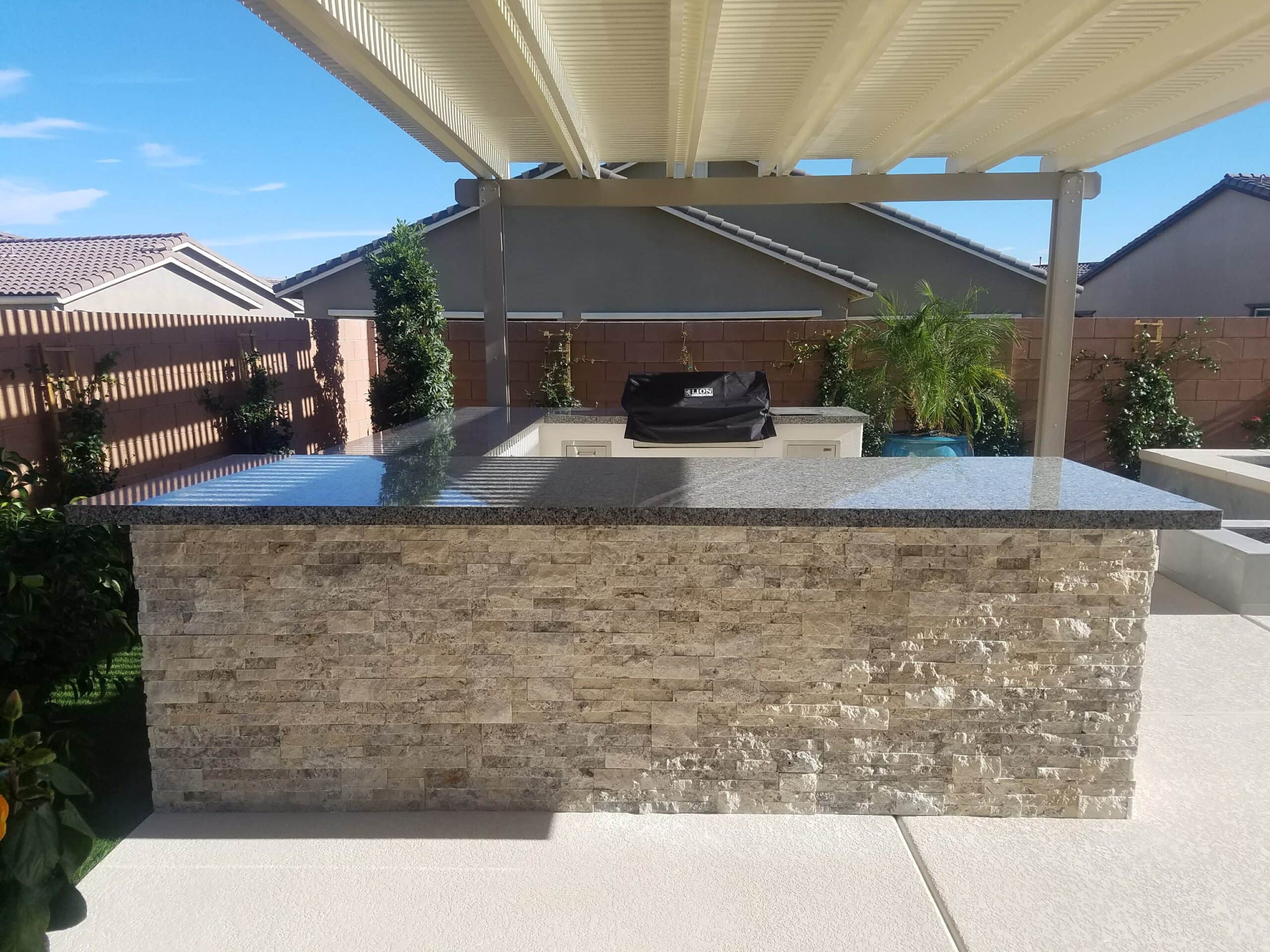 Curved stacked-stone BBQ island with dark counter in Las Vegas