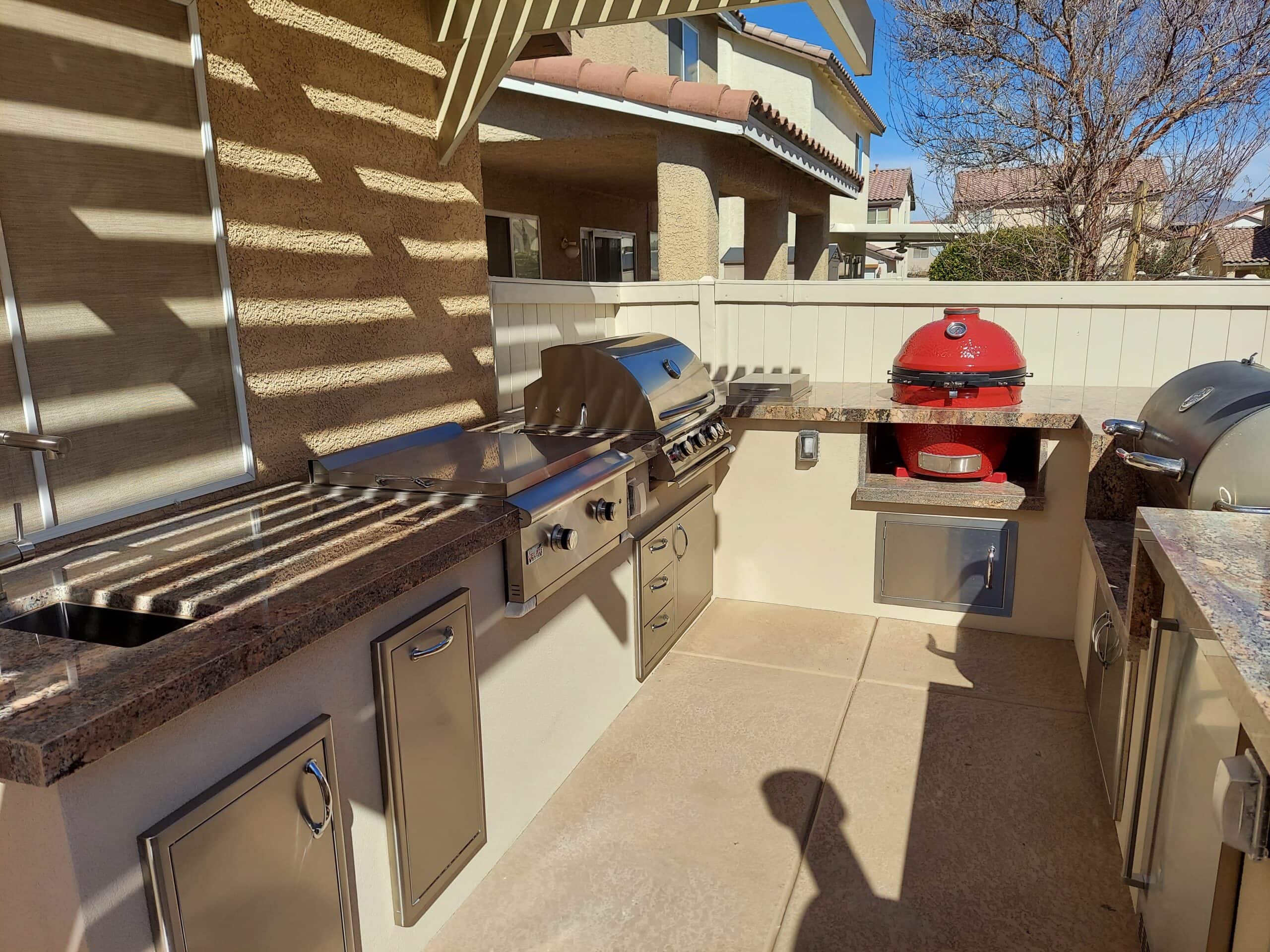 Red kamado grill built into a custom outdoor kitchen island in Las Vegas