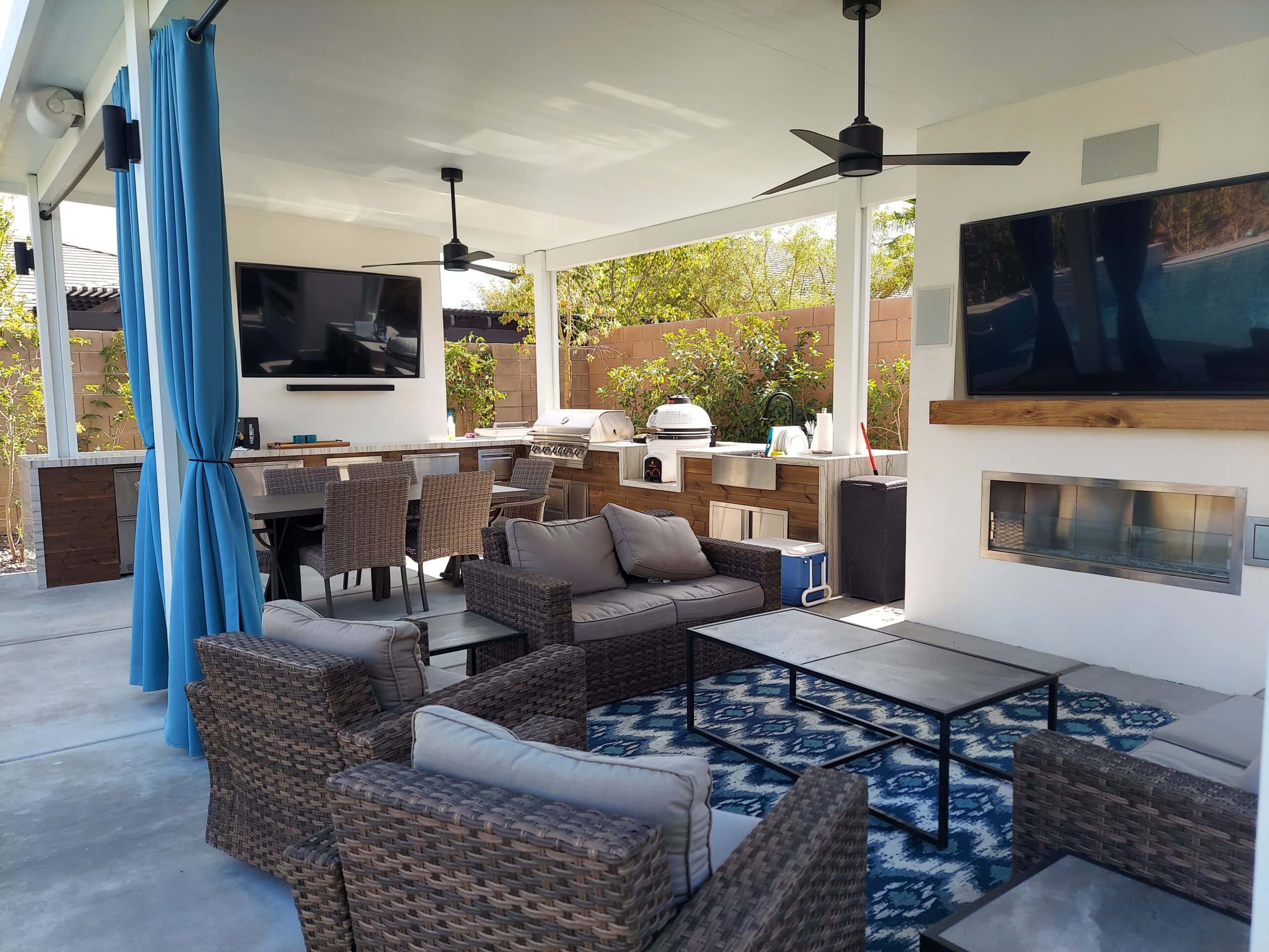 Covered patio entertaining space with outdoor kitchen, TV, and lounge seating in Las Vegas
