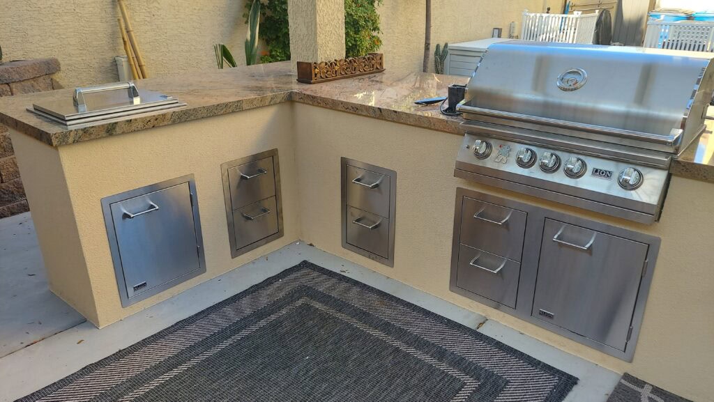 Custom outdoor kitchen island with built-in grill in a Las Vegas backyard