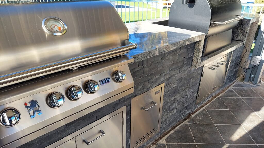 Built-in stainless grill in a stacked-stone outdoor kitchen island in Las Vegas