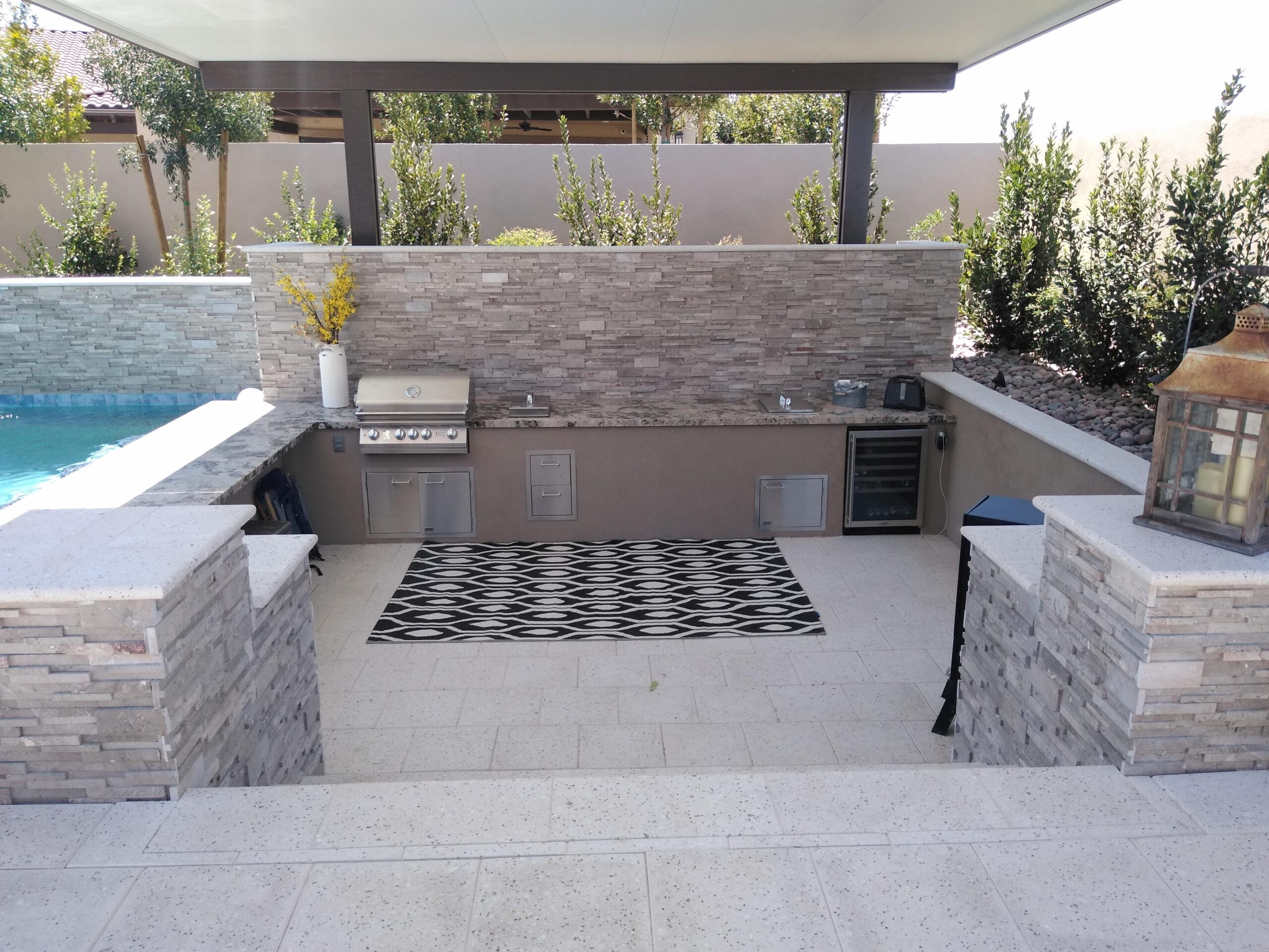 Stacked stone outdoor kitchen beside a pool in Las Vegas