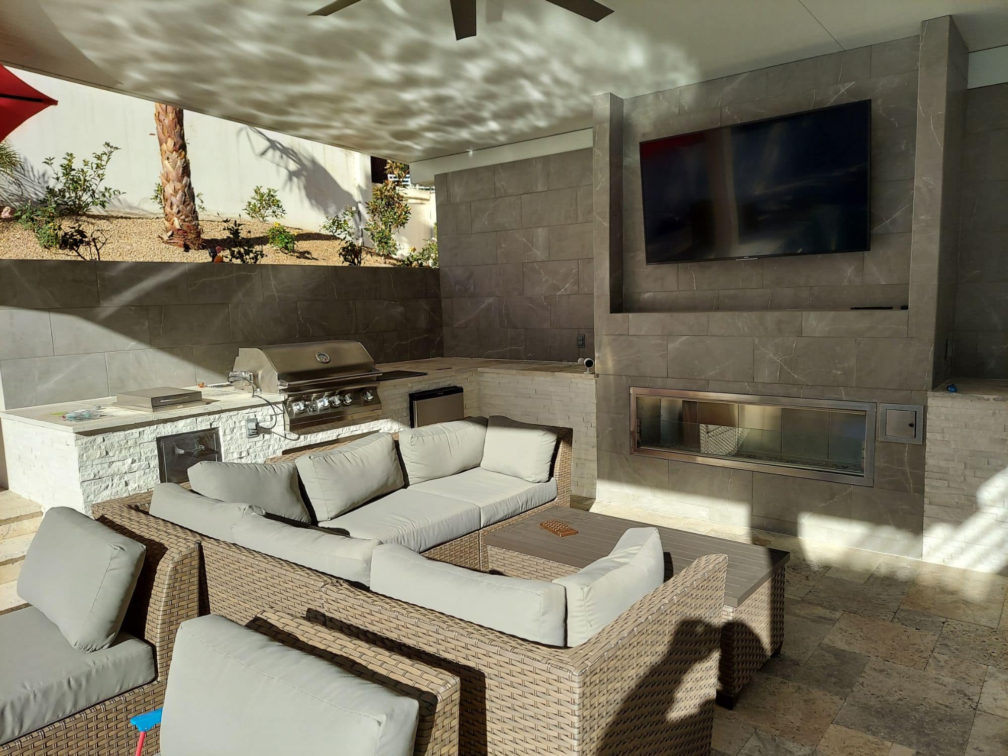 Covered patio outdoor kitchen with media wall and fireplace in Las Vegas