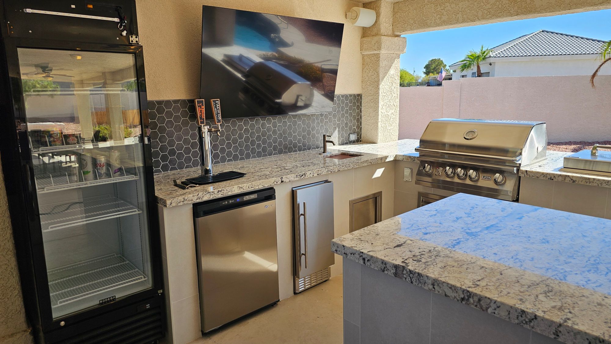 Outdoor kitchen with Lion 32-inch grill, dual beer tap and glass-front fridge in Las Vegas